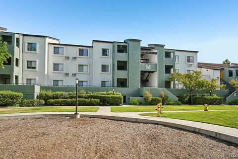 Apartment complex with a green lawn in front.
