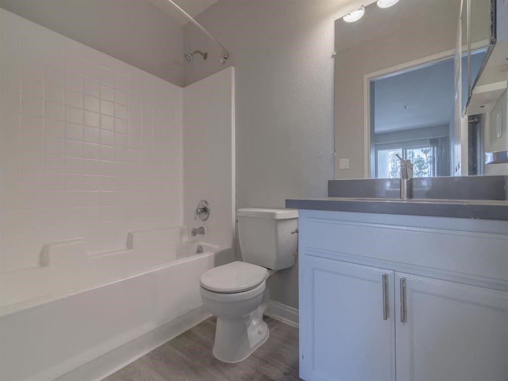 a bathroom with a toilet and a tub and a sink at Warner Center Townhomes, Canoga Park
