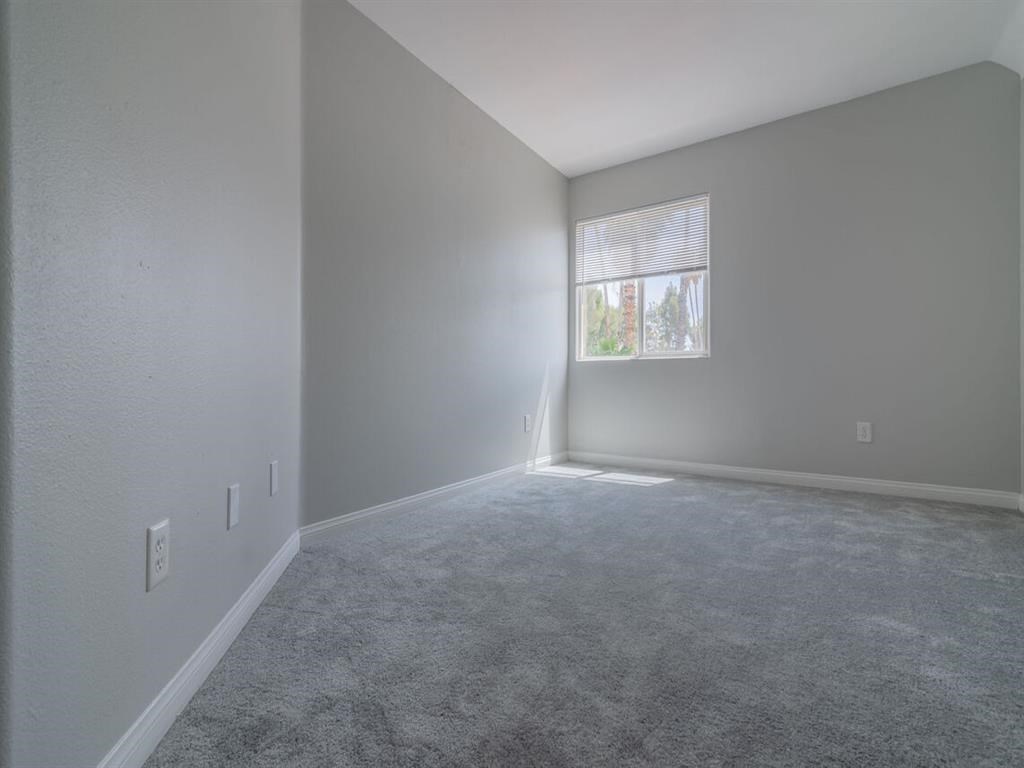 an empty living room with a window and carpet at Warner Center Townhomes, Canoga Park, CA 