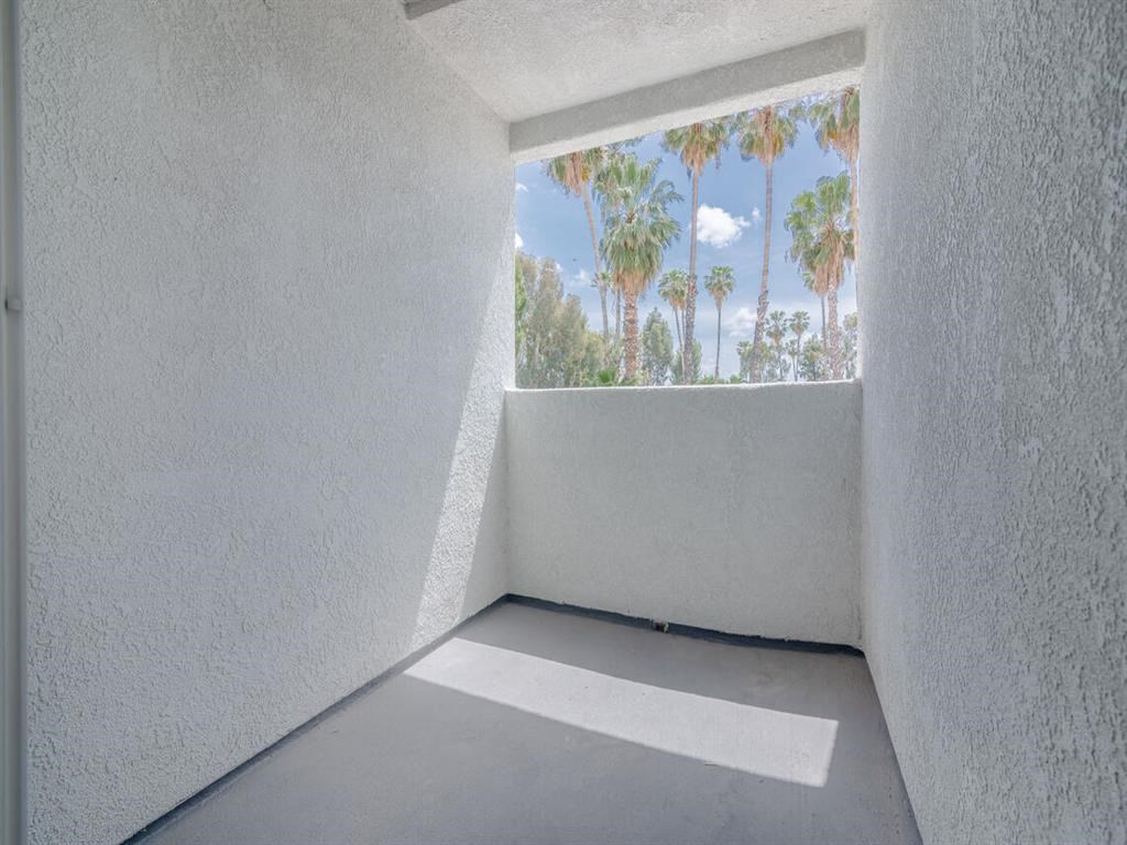 a view of palm trees from a window in a white room at Warner Center Townhomes, California
