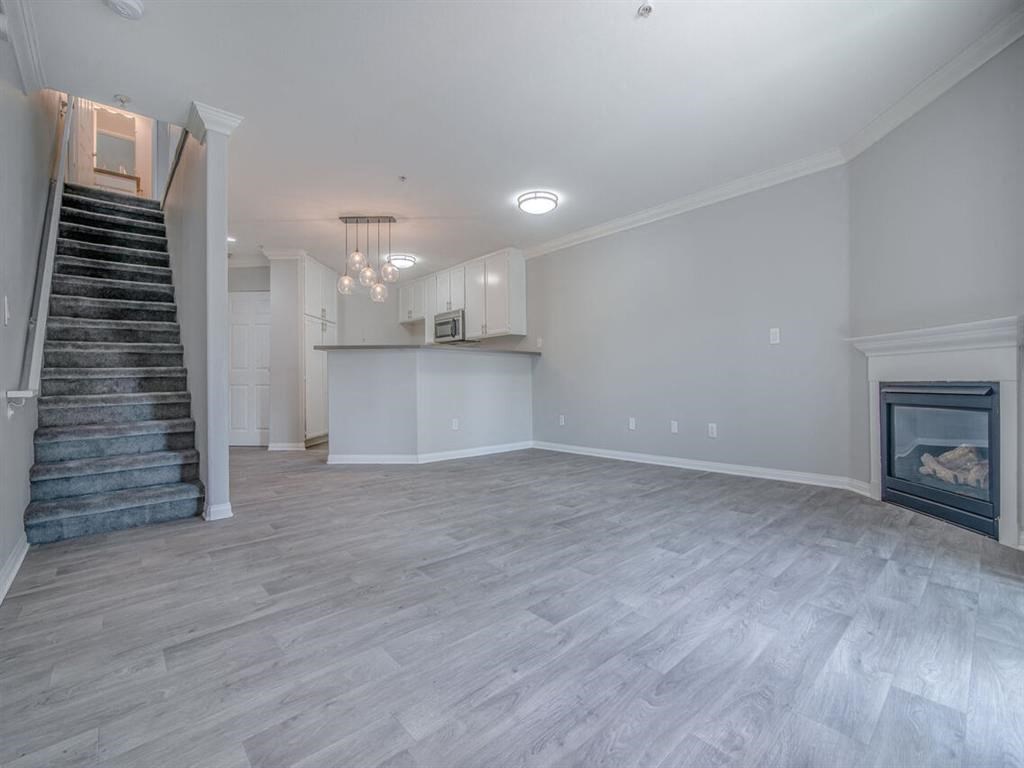 an empty living room with a fireplace and a staircase at Warner Center Townhomes, Canoga Park, CA 91303