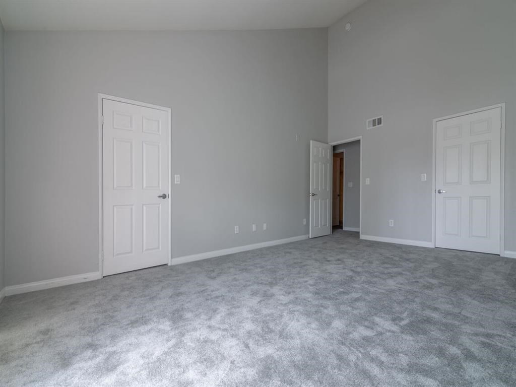 a bedroom with a carpeted floor and two doors at Warner Center Townhomes, California