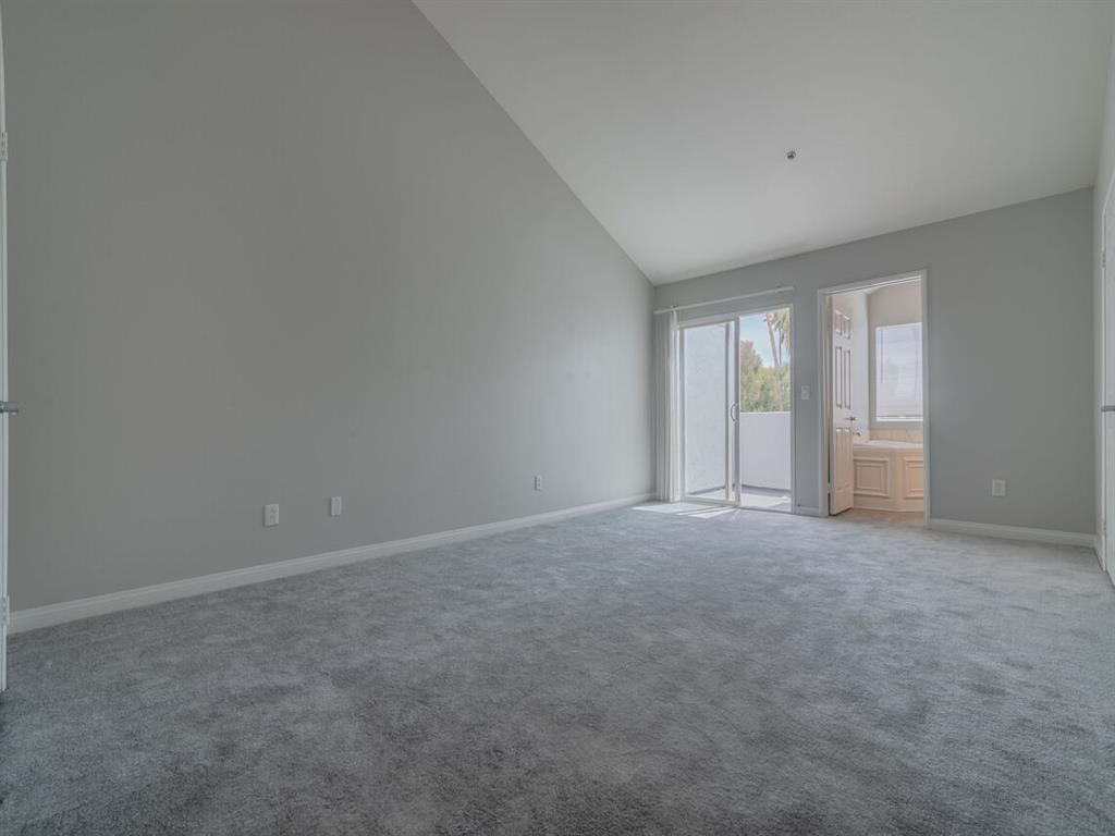 an empty living room with white walls and a door at Warner Center Townhomes, Canoga Park, CA 