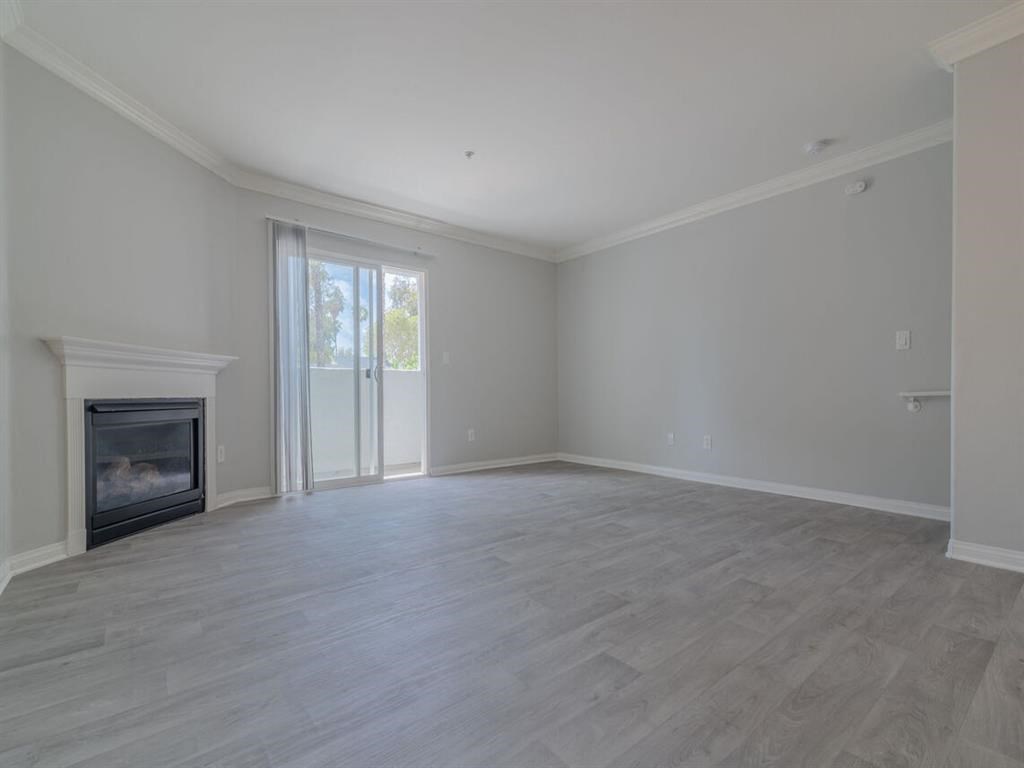 an empty living room with a fireplace and a sliding glass door at Warner Center Townhomes, Canoga Park, 91303