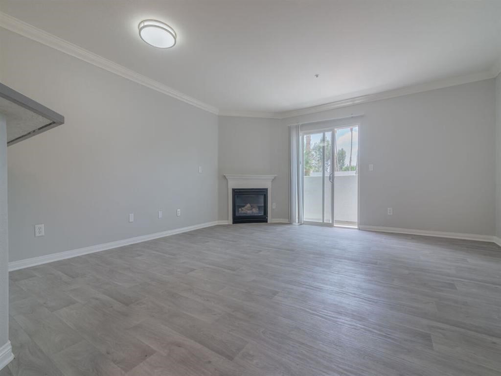 an empty living room with a fireplace and a sliding glass door at Warner Center Townhomes, Canoga Park, CA 91303