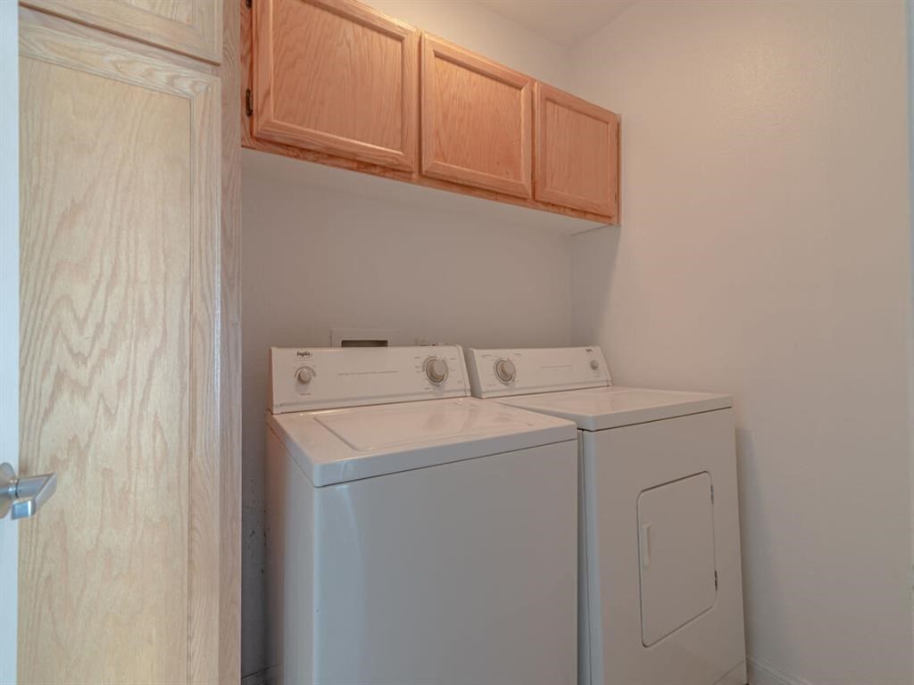 a washer and dryer in a room with wooden cabinets at Warner Center Townhomes, Canoga Park, CA