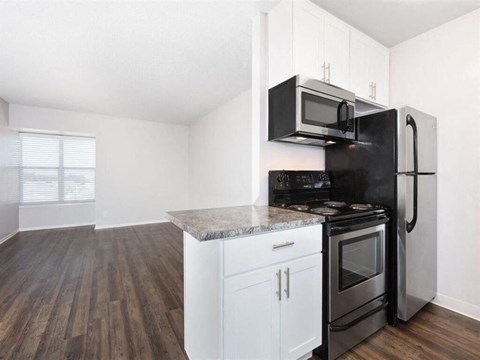 an empty kitchen with a stove refrigerator and microwave at Skyline Heights Apartments, Daly City