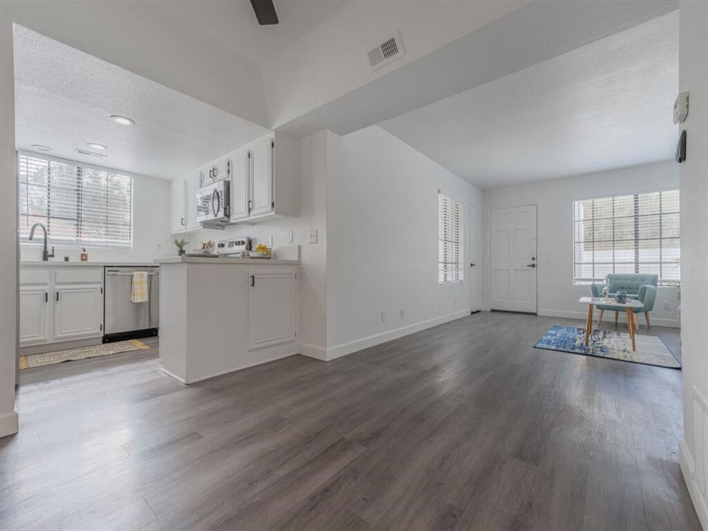 an empty living room and kitchen with wood floors  at The Resort at Encinitas Luxury Apartment Homes, Encinitas, California