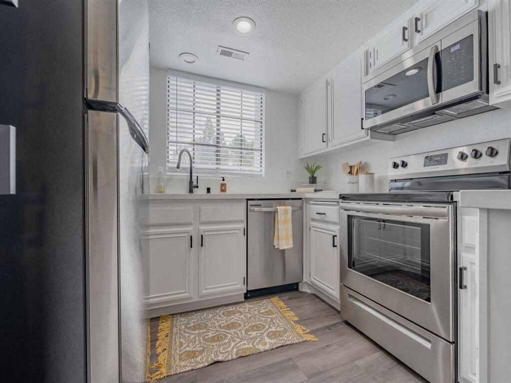 a kitchen with stainless steel appliances and white cabinets  at The Resort at Encinitas Luxury Apartment Homes, Encinitas, 92024