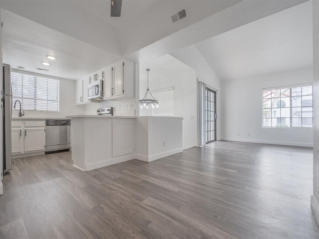 an empty kitchen and living room with a large window  at The Resort at Encinitas Luxury Apartment Homes, Encinitas, CA