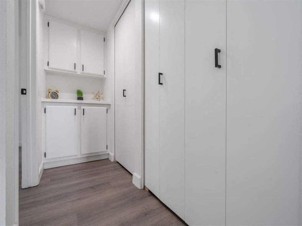 a white kitchen with white cabinets and a wood floor  at The Resort at Encinitas Luxury Apartment Homes, Encinitas, 92024