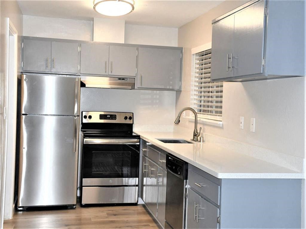 a kitchen with stainless steel appliances and white counter tops at Trailhead Apartments at Tam Junction, Mill Valley