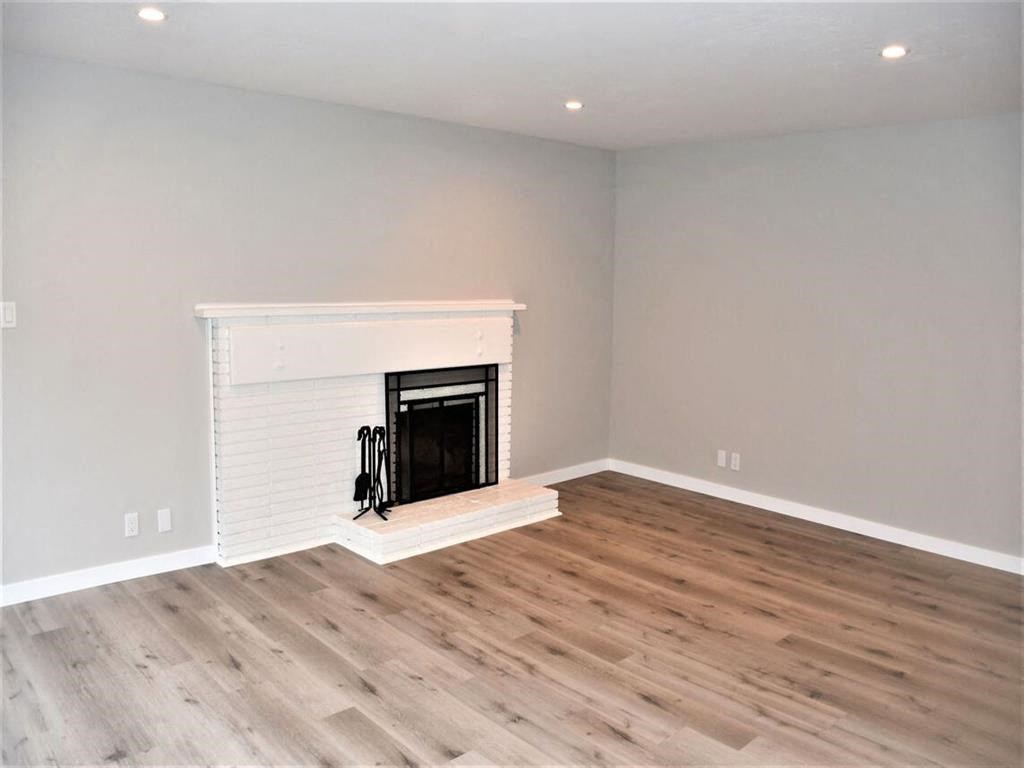 a living room with a fireplace and wooden floors at Trailhead Apartments at Tam Junction, Mill Valley, 94941