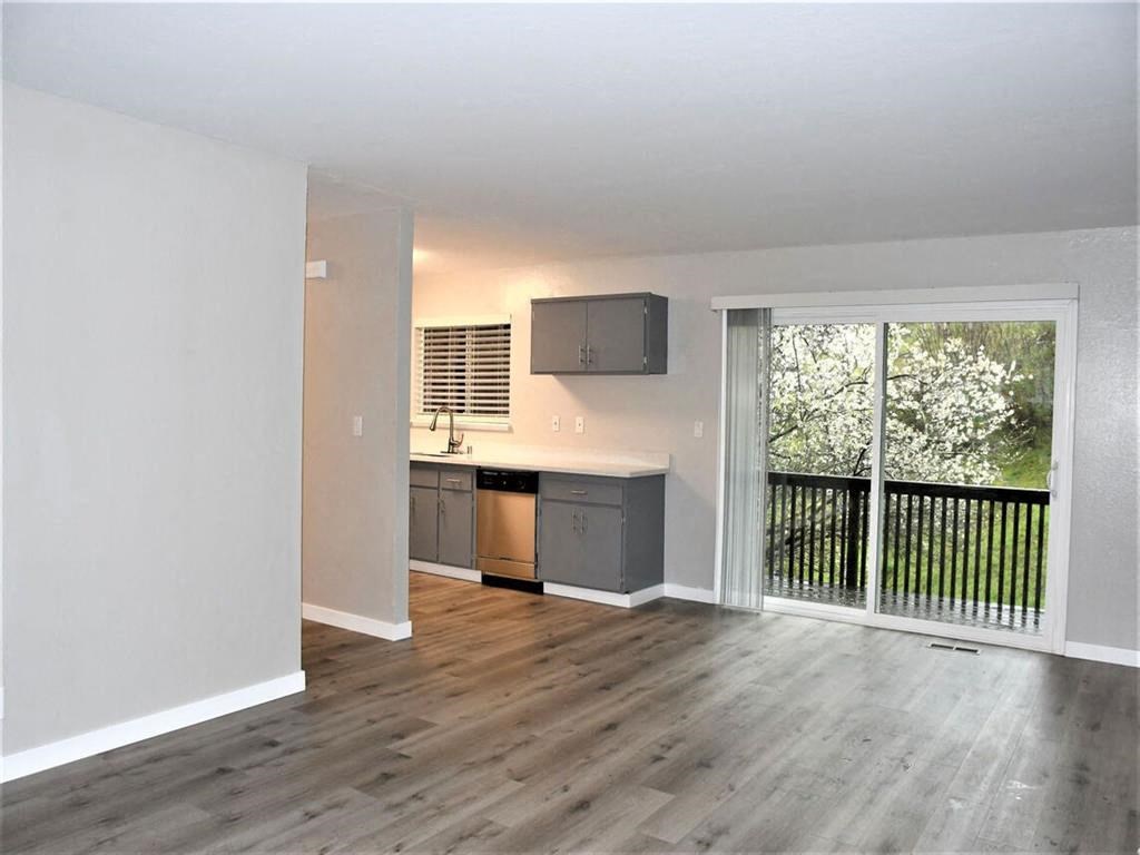an empty living room with a sliding glass door to a balcony at Trailhead Apartments at Tam Junction, Mill Valley, CA 94941