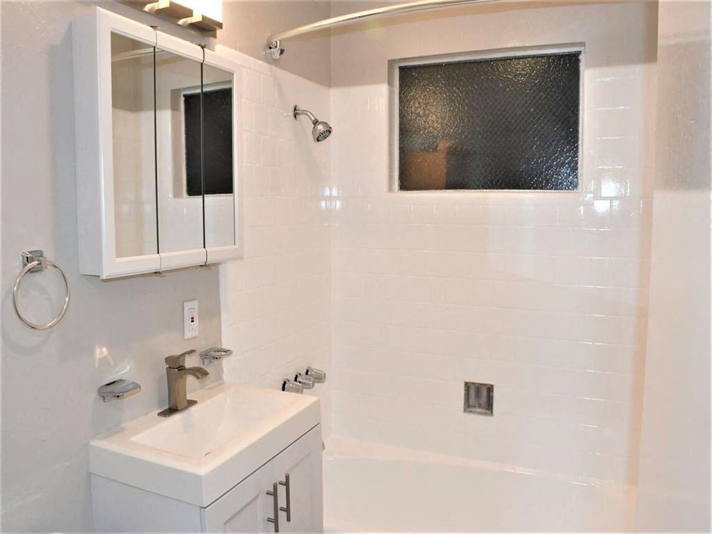 a white bathroom with a sink and a bath tub at Trailhead Apartments at Tam Junction, Mill Valley, CA