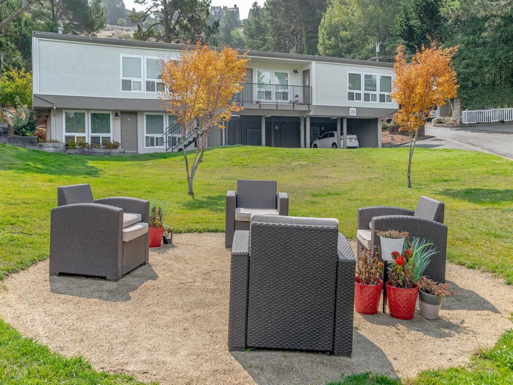 a patio with chairs and a table in front of a building at Trailhead Apartments at Tam Junction, Mill Valley, CA