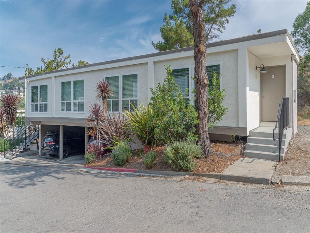 a white house with a driveway and a tree in front of it at Trailhead Apartments at Tam Junction, Mill Valley, 94941