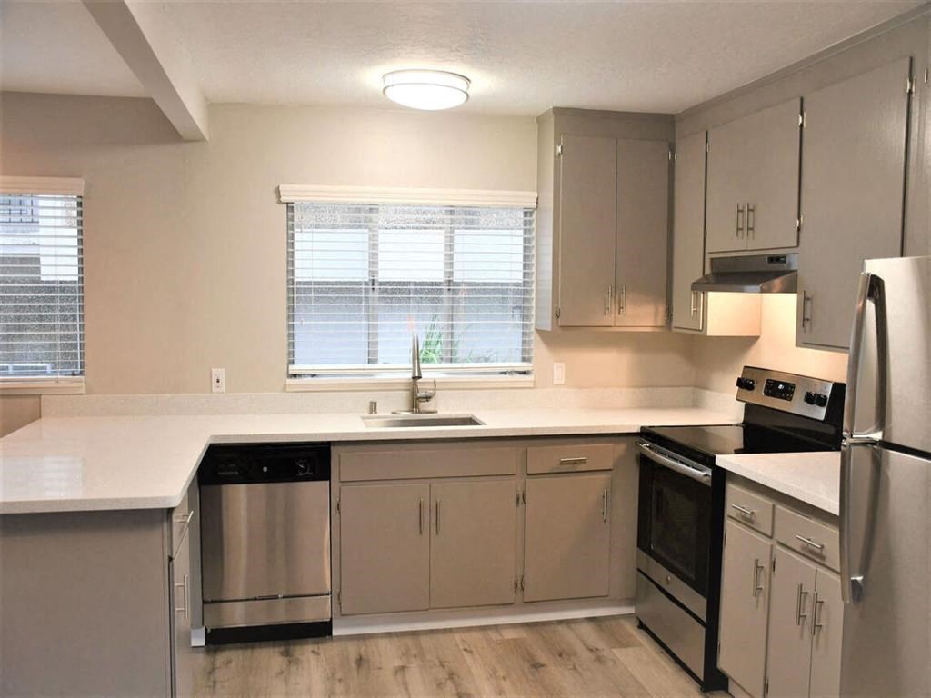 an empty kitchen with white counter tops and stainless steel appliances at Trailhead Apartments at Tam Junction, Mill Valley, CA