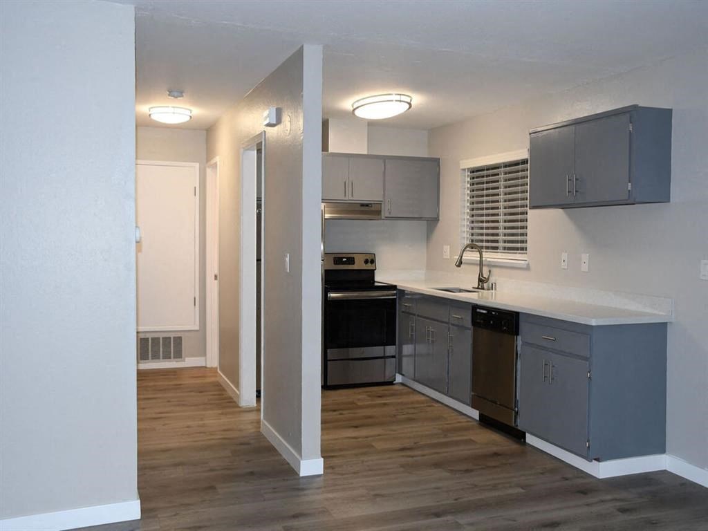 an empty kitchen with stainless steel appliances and a wooden floor at Trailhead Apartments at Tam Junction, Mill Valley, CA 94941