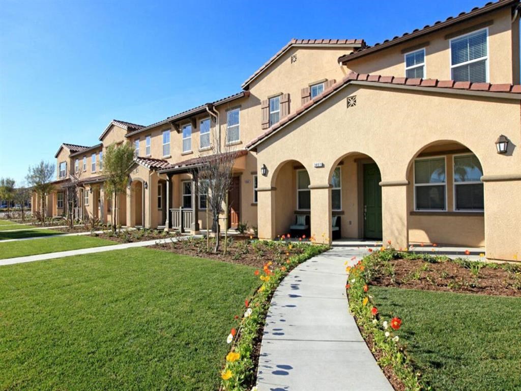 a sidewalk in front of a building with grass at The Vines at Riverpark, LLC, California, 93036