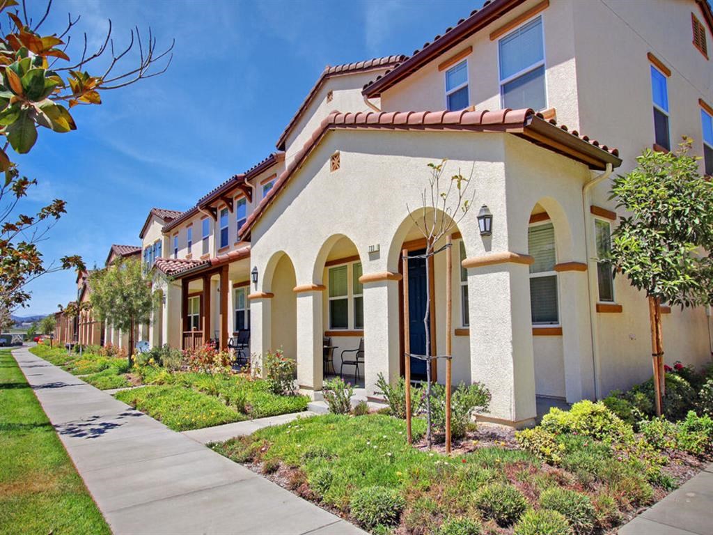 a row of houses with a sidewalk in front of them at The Vines at Riverpark, LLC, Oxnard, 93036