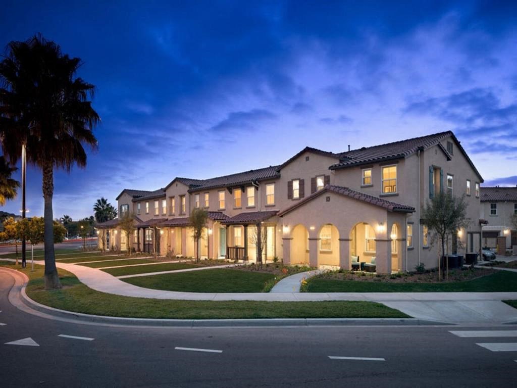 a large building with a palm tree in front of it at The Vines at Riverpark, LLC, Oxnard, CA
