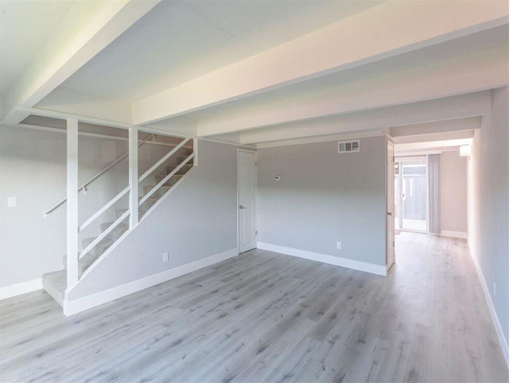 an empty living room with white walls and a staircase at The Preston at Hillsdale, San Mateo, 94403
