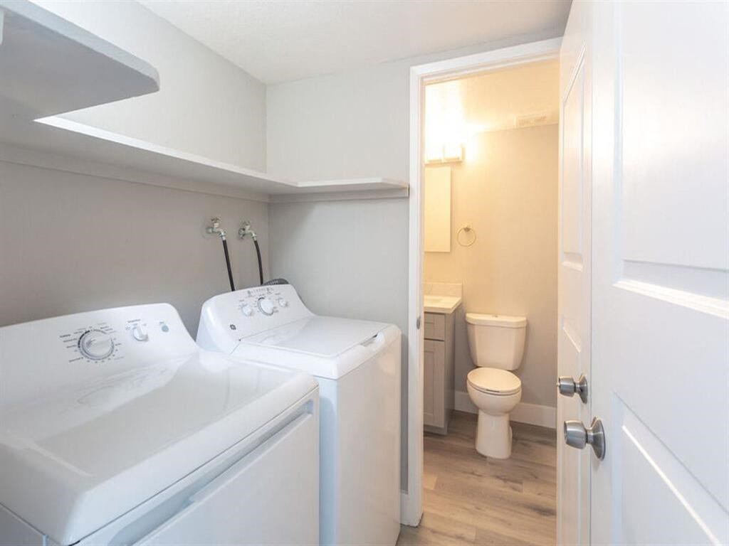 a bathroom with a washer and dryer and a toilet  at The Preston at Hillsdale, San Mateo, California