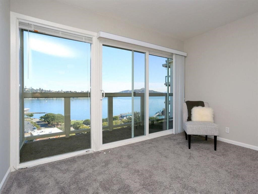 a living room with a view of a lake and a chair at The Pier at Sausalito, Sausalito, 91360