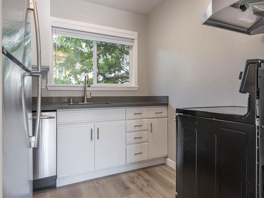 a kitchen with white cabinets and a window at The Pier at Sausalito, Sausalito, CA