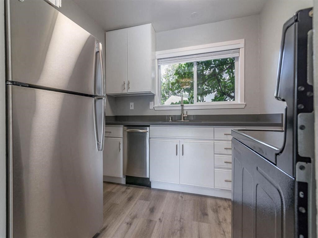 a kitchen with white cabinets and a window at The Pier at Sausalito, Sausalito California