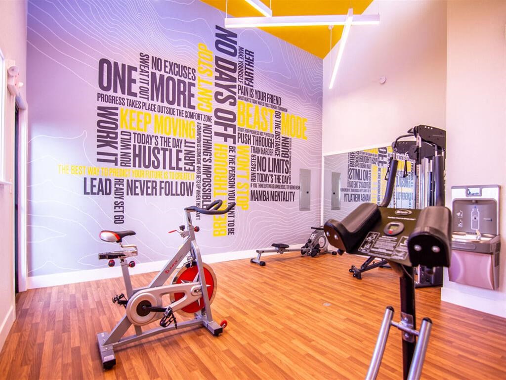 a gym with a wall covered in gym equipment at Parc Medallion LLC, California