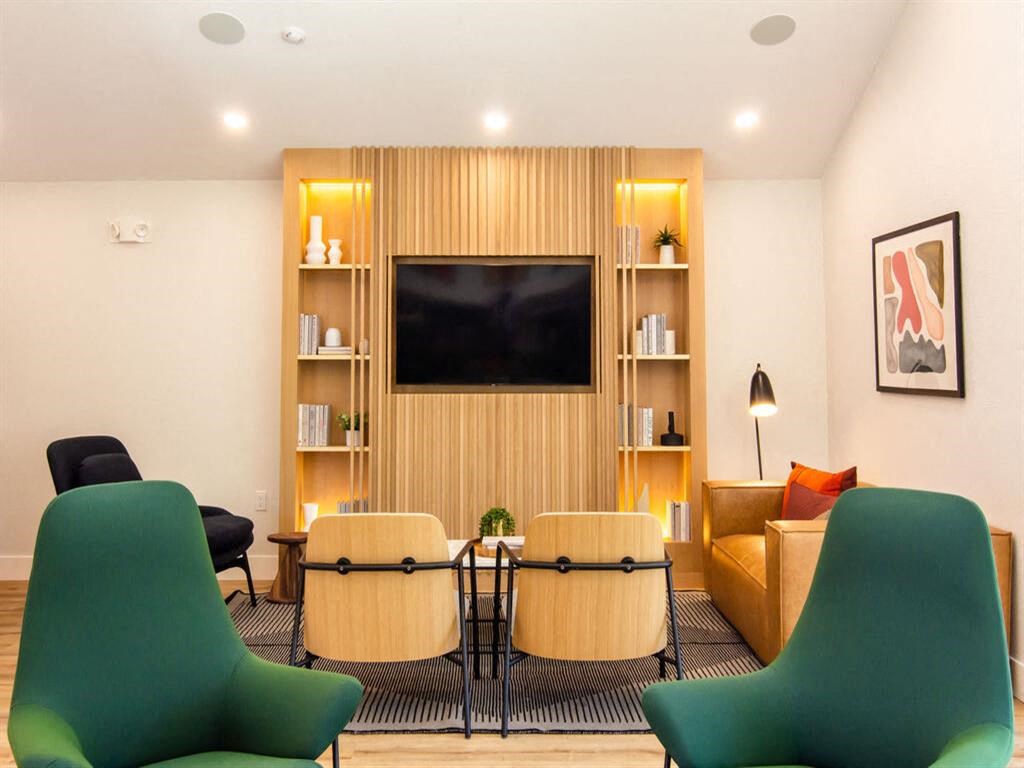 a living room with a table and chairs and a television at Parc Medallion LLC, Union City, 94587