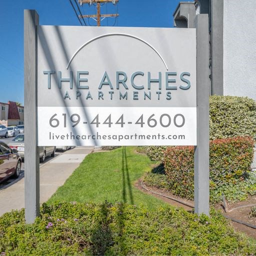 a sign for the arches apartments on the side of a street at The Arches Apartments, El Cajon, CA