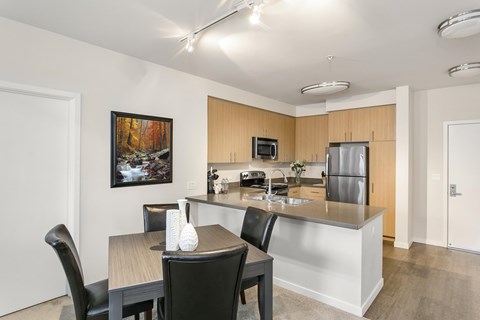 A kitchen with a table and chairs and a painting on the wall.