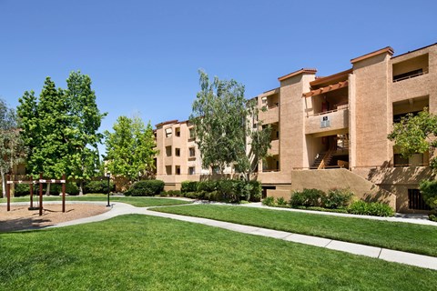 A playground area is located in front of apartment buildings. at The Maddox Sunnyvale Apartments, California