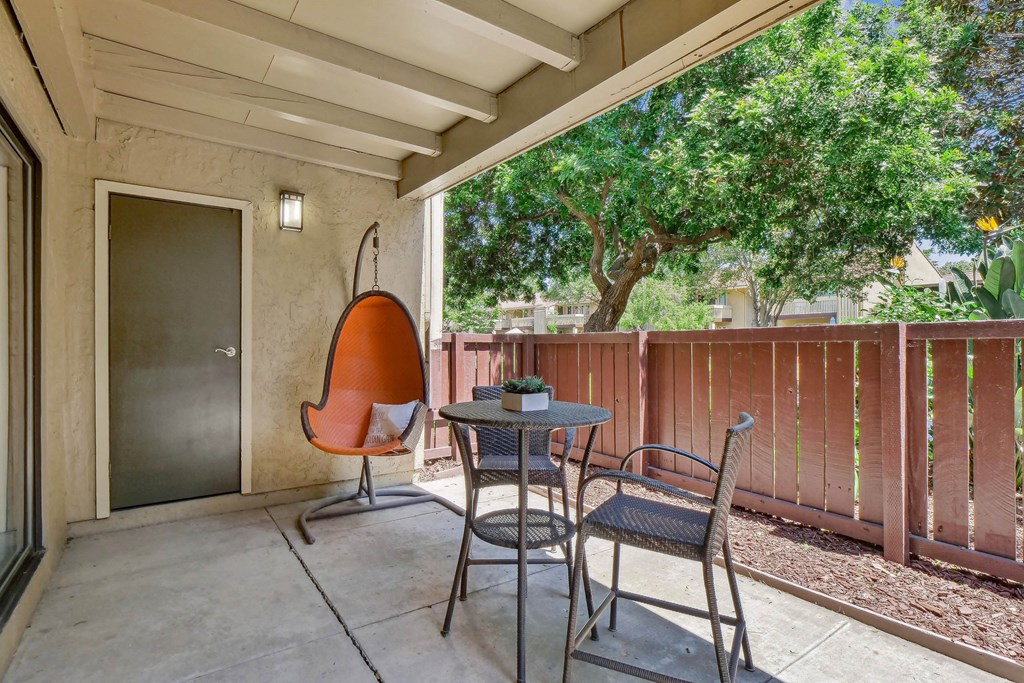 a patio with two chairs and a table and a door at Summerwood Apartments, Santa Clara