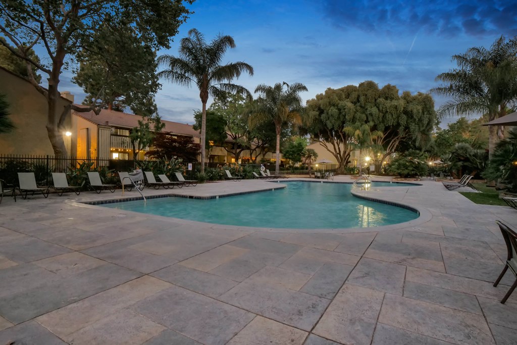 a large pool with chairs around it at night at Summerwood Apartments, Santa Clara, California