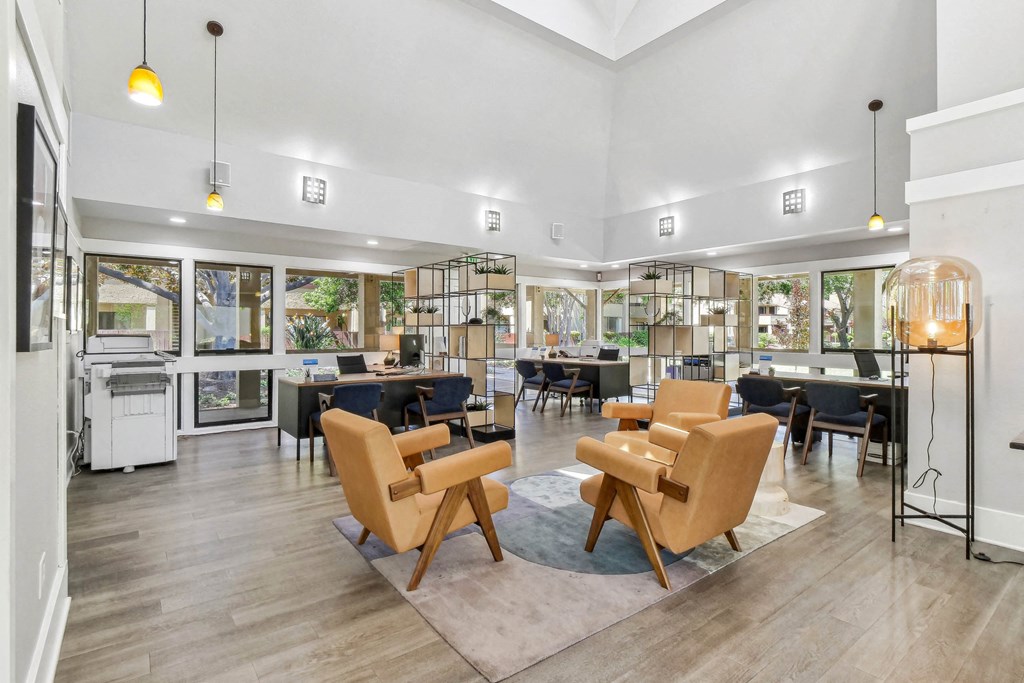 a living room with chairs and tables and a library at Summerwood Apartments, Santa Clara, CA