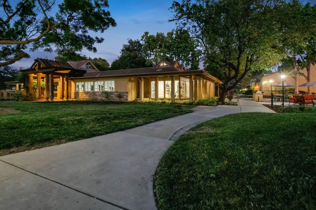 the house is lit up at night with the sidewalk in front of it at Summerwood Apartments, Santa Clara, California