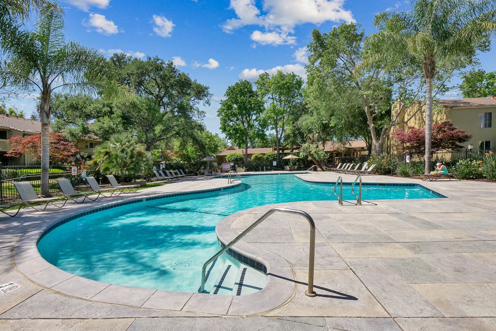 a swimming pool with trees in the background at Summerwood Apartments, California, 95050
