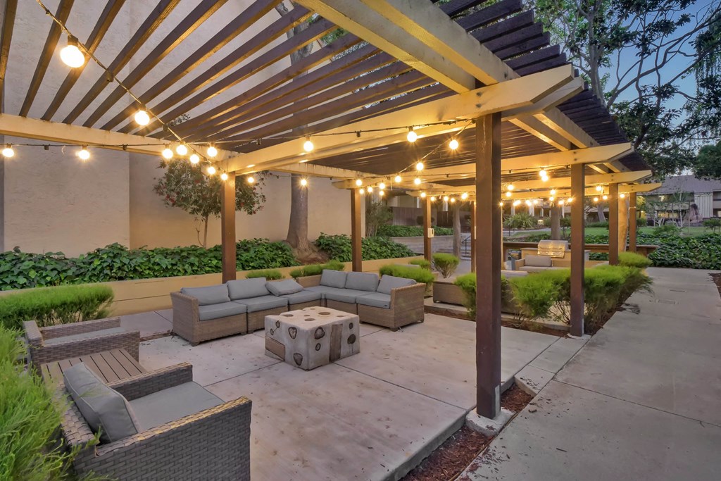 a patio with couches and a canopy with lights at Summerwood Apartments, Santa Clara
