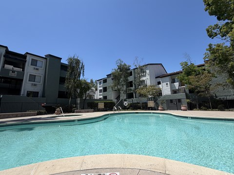 A swimming pool in front of apartment buildings.
