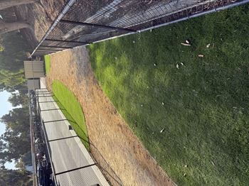 A grassy area with a fence and a building in the background.