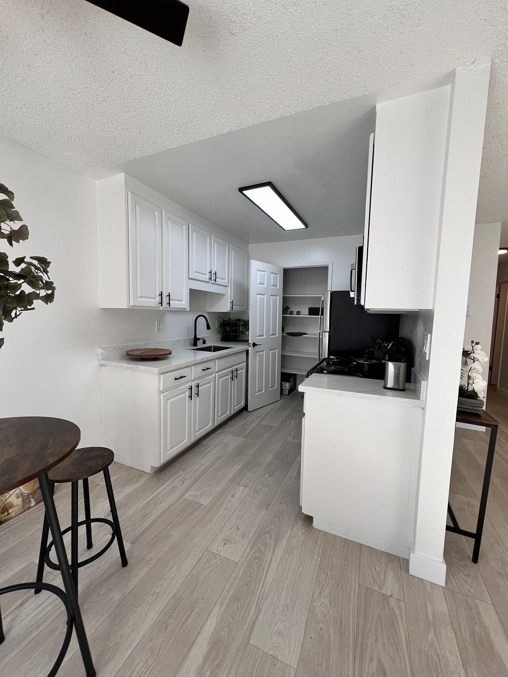 an open kitchen and dining area with white cabinets and a counter top at Campbell West Apartments, Campbell, CA 95008