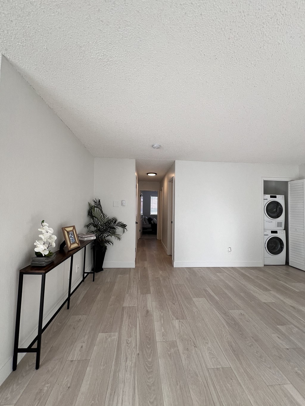 a living room with a wood floor and a washer and dryer in it at Campbell West Apartments, Campbell, 95008