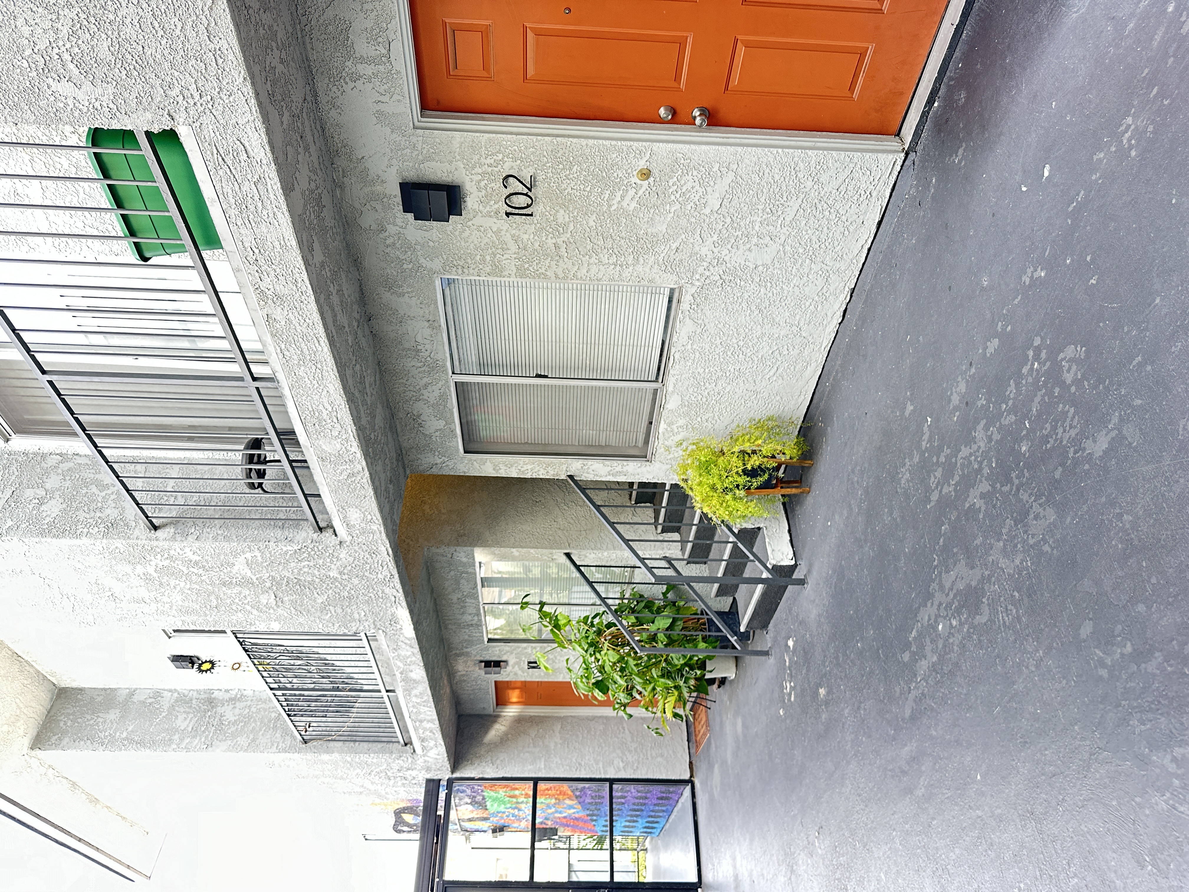 a view of a courtyard with stairs and an orange door