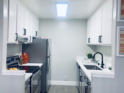 a kitchen with white cabinets and a stainless steel refrigerator
