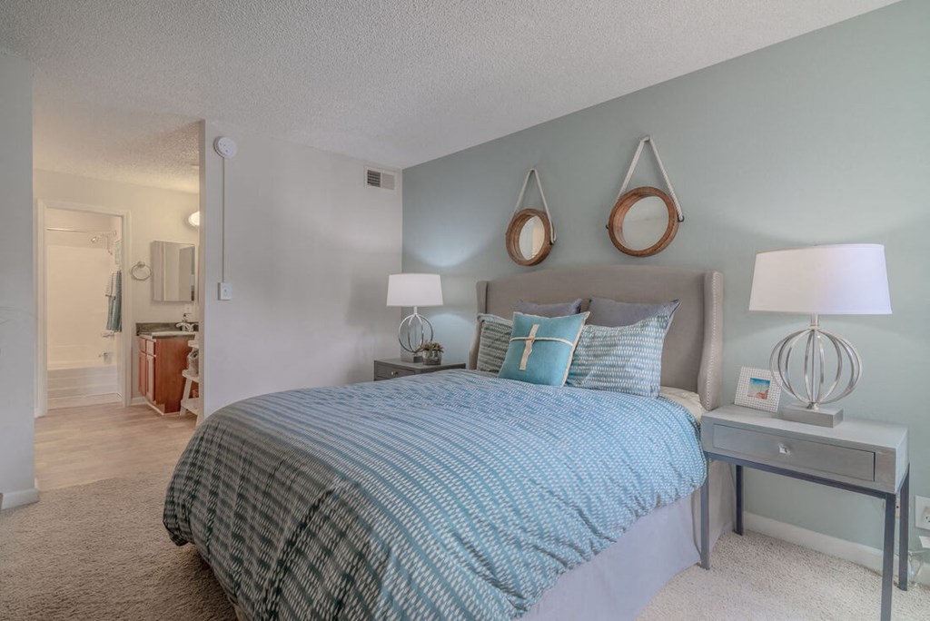 a bedroom with a bed and lamps and a mirror at City View Apartments at Warner Center, Woodland Hills, CA