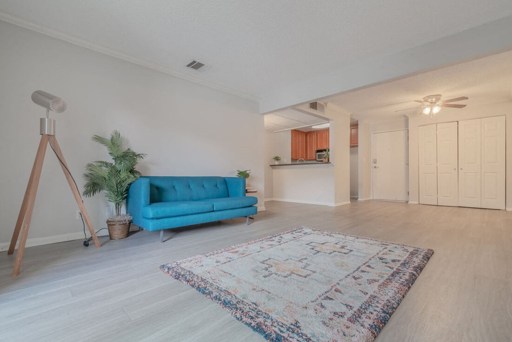 a living room with a blue couch and a carpet at City View Apartments at Warner Center, Woodland Hills California